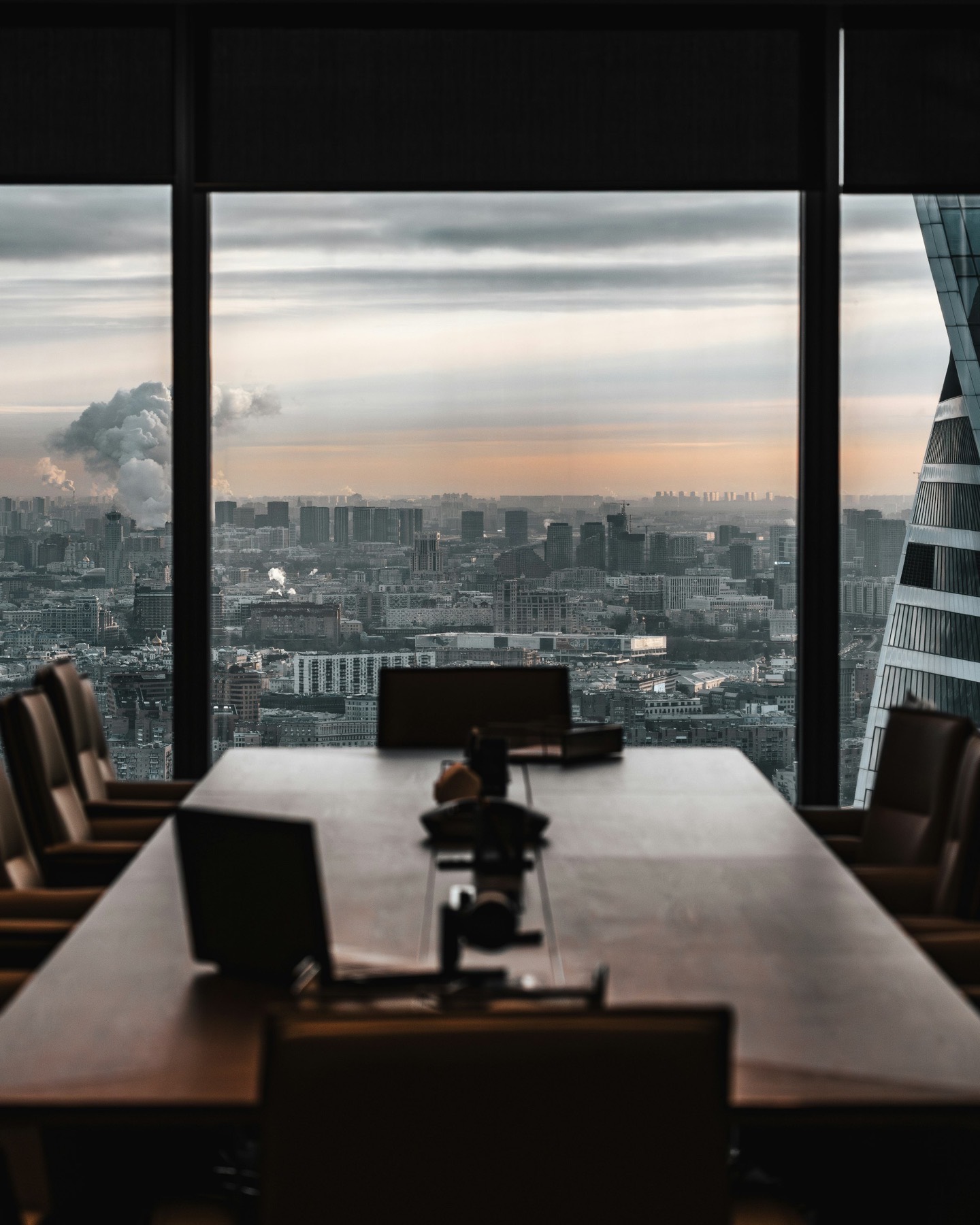 An empty conference table overlooking the city at dusk